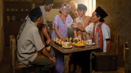 Sebuah keluarga Indonesia berbagi tawa dan cerita di meja makan, jauh dari gangguan gawai. Momen sederhana seperti ini krusial untuk membangun kembali kehangatan dan kedekatan emosional di tengah hiruk pikuk kehidupan modern.