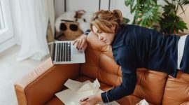Seorang wanita terlihat sedang menyeimbangkan berbagai elemen pekerjaan dan kehidupan pribadinya, menggambarkan tantangan dalam mencapai produktivitas optimal tanpa mengalami *burnout*. Ini merefleksikan pentingnya manajemen energi dan strategi kerja cerdas di tengah tuntutan karier yang terus meningkat.