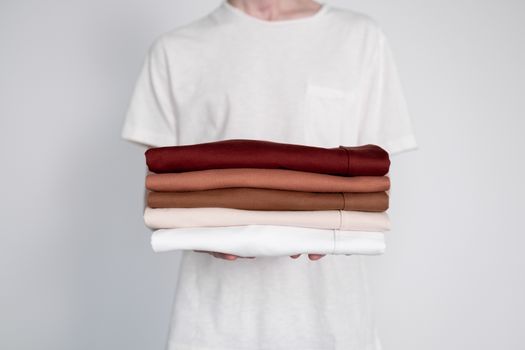 Seorang wanita mengenakan busana bergaya minimalis dengan siluet bersih dan warna netral yang elegan, dipadukan dengan aksesori yang menampilkan sentuhan etnik Indonesia yang kaya, mencerminkan tren fashion terkini. Pakaian ini menonjolkan perpaduan harmonis antara kesederhanaan modern dan kekayaan budaya lokal yang kini mendunia.
