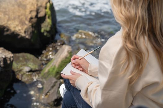 Seorang wanita tersenyum damai sambil menulis di jurnal, mencerminkan momen refleksi diri dan penemuan kebahagiaan di tengah alam yang menenangkan. Kegiatan menulis jurnal dapat menjadi salah satu ritual penting untuk memupuk kebahagiaan dan mengidentifikasi nilai-nilai hidup yang sesungguhnya.
