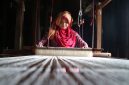 Model mengenakan busana yang memadukan tenun ikat tradisional Indonesia dengan desain kontemporer, merefleksikan tren mode 2026 yang mengedepankan keberlanjutan dan identitas lokal. Pilihan material ramah lingkungan dan sentuhan estetika retro menambah dimensi baru pada koleksi yang relevan untuk gaya hidup modern.