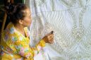 Seorang model mengenakan blus batik kontemporer dengan motif geometris yang cerah, memadukan tradisi dan gaya modern, menunjukkan bagaimana batik telah berevolusi menjadi bagian integral dari fesyen sehari-hari anak muda urban.
