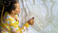 Seorang model mengenakan blus batik kontemporer dengan motif geometris yang cerah, memadukan tradisi dan gaya modern, menunjukkan bagaimana batik telah berevolusi menjadi bagian integral dari fesyen sehari-hari anak muda urban.