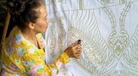 Seorang model mengenakan blus batik kontemporer dengan motif geometris yang cerah, memadukan tradisi dan gaya modern, menunjukkan bagaimana batik telah berevolusi menjadi bagian integral dari fesyen sehari-hari anak muda urban.