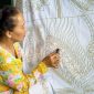Seorang model mengenakan blus batik kontemporer dengan motif geometris yang cerah, memadukan tradisi dan gaya modern, menunjukkan bagaimana batik telah berevolusi menjadi bagian integral dari fesyen sehari-hari anak muda urban.