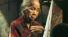 Seorang wanita mengenakan kain batik sedang menata dagangan rempah di pasar tradisional, mencerminkan kekayaan budaya dan gaya hidup lokal Indonesia yang masih sangat kental dengan nuansa tradisional. Pemandangan ini menunjukkan betapa kuatnya akar budaya dalam kehidupan sehari-hari masyarakat kita.