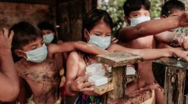 Seorang anak di pedesaan Kalimantan Selatan sedang minum air bersih dari keran umum, yang menunjukkan pentingnya akses terhadap sumber air minum layak untuk mencegah masalah kesehatan seperti stunting. Upaya pemerintah dan komunitas terus digalakkan untuk memastikan setiap keluarga mendapatkan akses sanitasi dan air bersih yang memadai.