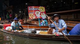 Pemandangan hidup pasar terapung di Kalimantan, di mana perahu-perahu tradisional dipenuhi hasil bumi segar berinteraksi dengan pembeli di tengah aliran sungai. Ini adalah cerminan otentik dari kehidupan sehari-hari dan warisan budaya yang tak ternilai harganya.