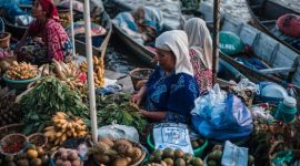 Ratusan perahu jukung berjejer rapi di Pasar Terapung Lok Baintan, Banjarmasin, menyuguhkan pemandangan aktivitas jual beli yang ramai dan penuh warna di pagi hari. Para pedagang menjajakan aneka hasil bumi dan makanan khas dari atas perahu, menciptakan suasana pasar yang sangat unik dan ikonik.