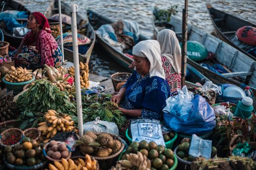 Ratusan perahu jukung berjejer rapi di Pasar Terapung Lok Baintan, Banjarmasin, menyuguhkan pemandangan aktivitas jual beli yang ramai dan penuh warna di pagi hari. Para pedagang menjajakan aneka hasil bumi dan makanan khas dari atas perahu, menciptakan suasana pasar yang sangat unik dan ikonik.