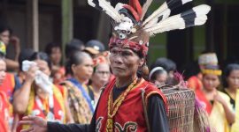 Masyarakat Dayak Meratus tengah melaksanakan ritual adat di balai desa, menunjukkan kekayaan spiritual dan kuatnya ikatan mereka dengan alam serta para leluhur. Tarian dan musik tradisional ini menjadi bagian penting dalam menjaga harmoni komunitas.