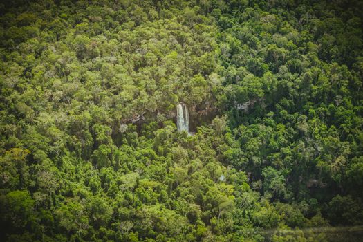 Air terjun Mandin Mangapan yang bertingkat-tingkat di Hutan Pegunungan Meratus, Kalimantan Selatan, menunjukkan keindahan alam yang masih asri, dengan latar belakang pepohonan rimbun yang menjadi rumah bagi keanekaragaman hayati unik.