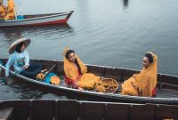 Sebuah jukung tradisional berlayar tenang di sungai, simbol kehidupan dan transportasi utama di Kalimantan Selatan. Perahu ini juga dimanfaatkan untuk membawa layanan kesehatan vital ke desa-desa terpencil.