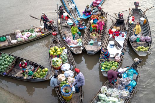 Para pedagang lokal sibuk menjajakan dagangan mereka dari atas perahu tradisional, menciptakan pemandangan khas pasar terapung yang ramai dan penuh warna di pagi hari. Aktivitas ini menunjukkan interaksi sosial dan ekonomi yang telah menjadi bagian integral dari kehidupan masyarakat setempat selama berabad-abad.