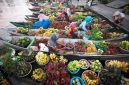 Pemandangan pedagang yang ramah menjajakan dagangan segar dari perahu kayu tradisional di salah satu pasar terapung di Indonesia, memperlihatkan kekayaan budaya dan kehidupan masyarakat lokal.