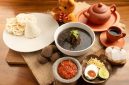 Semangkuk soto Banjar hangat lengkap dengan potongan lontong, telur rebus, dan taburan bawang goreng, siap memanjakan lidah dengan kekayaan rempah khas Kalimantan. Hidangan ini menjadi daya tarik utama kuliner di Banjarmasin.