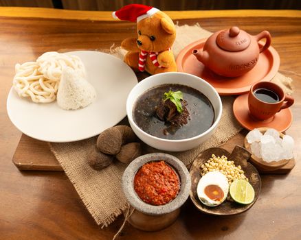 Semangkuk soto Banjar hangat lengkap dengan potongan lontong, telur rebus, dan taburan bawang goreng, siap memanjakan lidah dengan kekayaan rempah khas Kalimantan. Hidangan ini menjadi daya tarik utama kuliner di Banjarmasin.