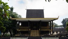 Patung Sultan Suriansyah berdiri gagah di Banjarmasin, mengenang pendiri Kesultanan Banjar yang mengubah arah sejarah wilayah ini dengan memeluk agama Islam. Terlihat pula latar belakang arsitektur tradisional Banjar yang mencerminkan kekayaan budaya yang telah diwariskan.