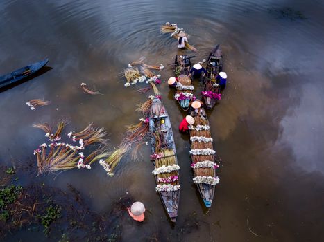 Pemandangan udara Sungai Barito yang membelah lanskap hijau Kalimantan, menunjukkan keindahan alami dan vitalitasnya sebagai jalur kehidupan utama bagi masyarakat di sekitarnya. Perahu-perahu tradisional terlihat berlayar tenang, menggambarkan harmoni antara manusia dan alam di tepian sungai yang megah ini.