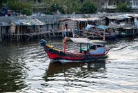 Sebuah perahu motor yang berfungsi sebagai puskesmas keliling tengah menyusuri sungai di Kalimantan Selatan, membawa harapan akan layanan kesehatan yang lebih mudah dijangkau bagi masyarakat di daerah terpencil. Tenaga medis dengan sigap memberikan pelayanan dan edukasi kesehatan langsung kepada warga di tepi sungai.