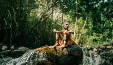 Seorang perempuan Suku Dayak Meratus dengan pakaian tradisionalnya, menyatu harmonis dengan rimbunnya hutan Kalimantan. Pakaian ini mencerminkan kekayaan budaya dan kedekatan mereka dengan alam yang menjadi sumber kehidupan.