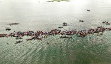Pemandangan Sungai Barito dari udara memperlihatkan jalur air yang membelah hutan lebat, menjadi arteri utama kehidupan di Pulau Kalimantan. Perahu-perahu tradisional tampak berlayar pelan, menyusuri riak Barito yang menyimpan ribuan cerita.