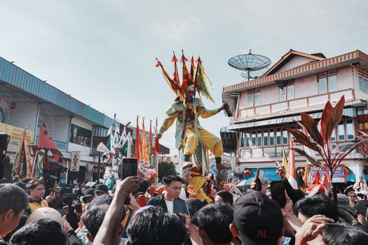 Seorang ibu mengayunkan anaknya dalam prosesi Baayun Mulud yang sarat makna di Kalimantan Selatan, dihiasi dengan kain motif dan janur kuning, melambangkan harapan serta doa bagi masa depan sang buah hati. Perayaan ini menjadi salah satu penanda kuat identitas budaya masyarakat Banjar, yang secara turun-temurun merayakannya setiap peringatan Maulid Nabi Muhammad SAW.
