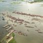 Pemandangan udara Sungai Barito dengan perahu-perahu tradisional yang melintas, menunjukkan peran vitalnya sebagai jalur transportasi dan denyut nadi kehidupan masyarakat Kalimantan.